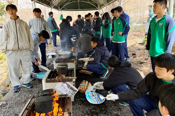 新入生合宿で飯ごう炊さんを行っている写真