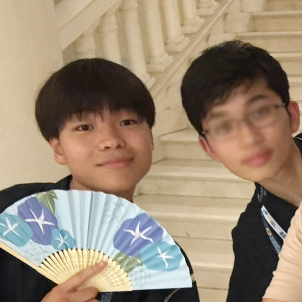 国際経済オリンピックの会場で、参加者と冨田さんの写真