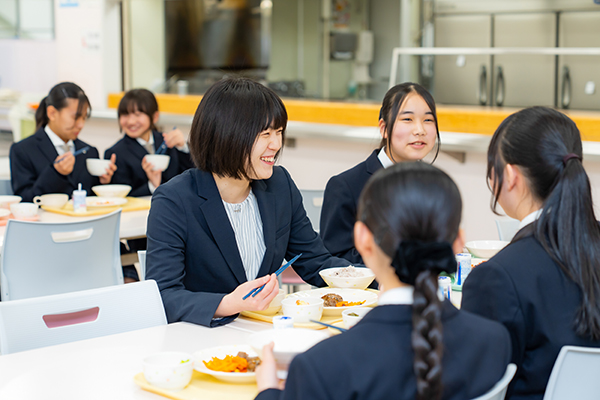 食堂で先生や生徒が和やかに昼食をとっている様子